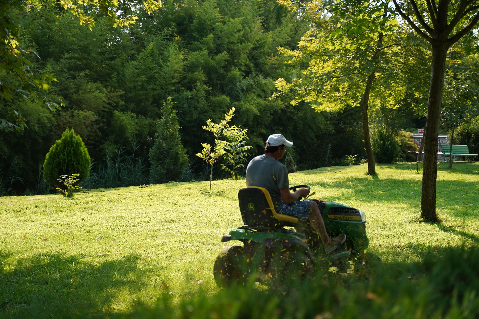 Push mower on a freshly cut green lawn beside a walkway